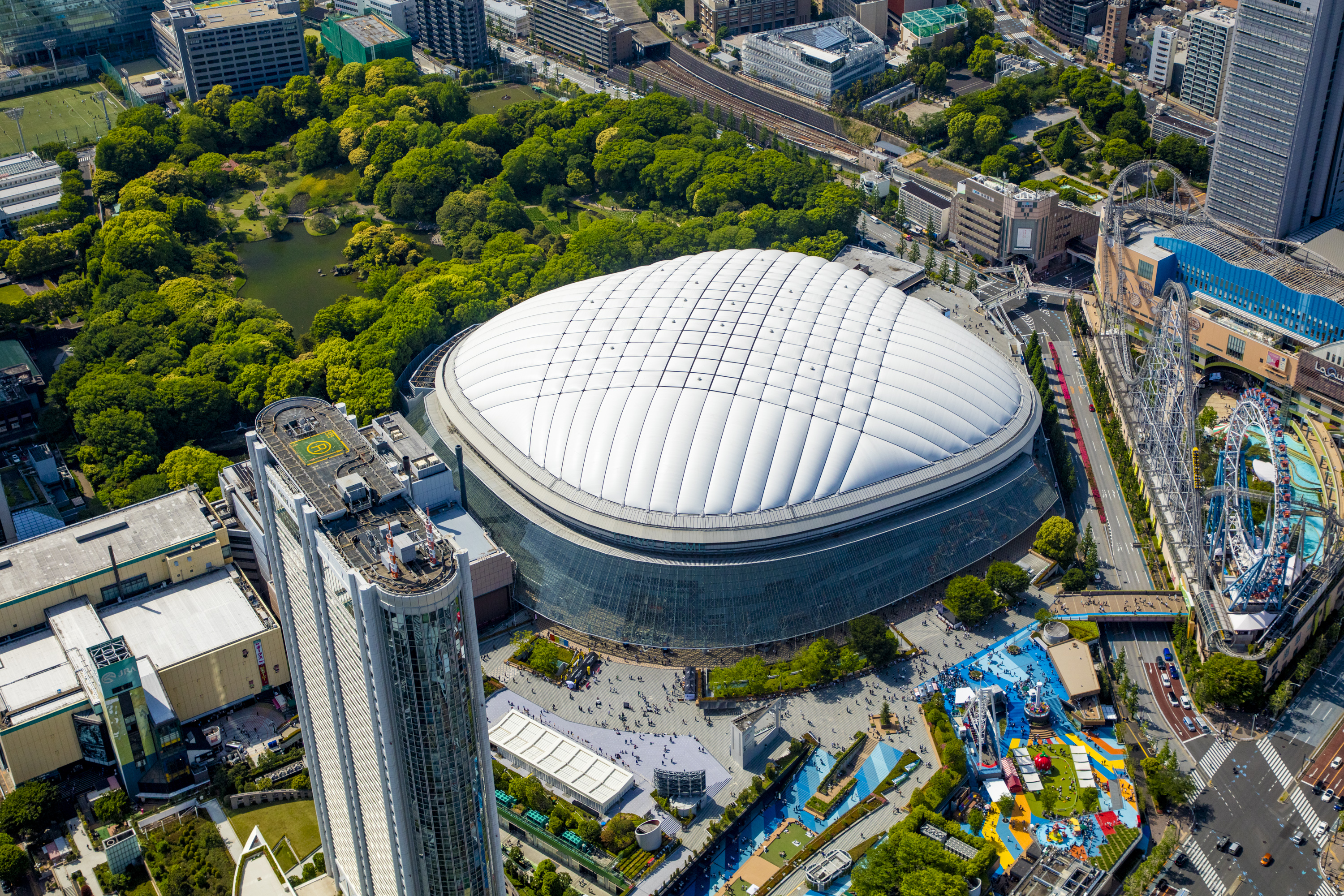 Tokyo Dome City aerial view showing the iconic stadium, amusement park, and entertainment complex with over 100,000 daily visitors